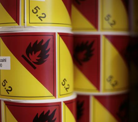 mehrfarbige Haftetiketten auf der Rolle mit Warnsymbol